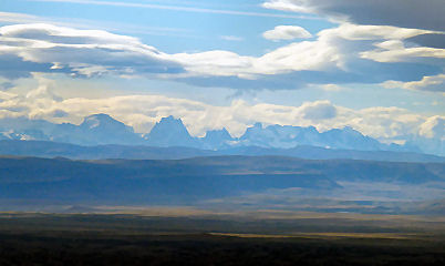 Dunstig am Horizont die circa 200 km entfernten Berge Cerro Torre und Mount Fitzroy
