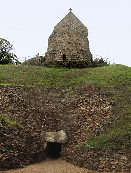 Zugang zum megalithischen Ganggrab La Hougue Bie unter dem kapellengekrönten Steinhügel
